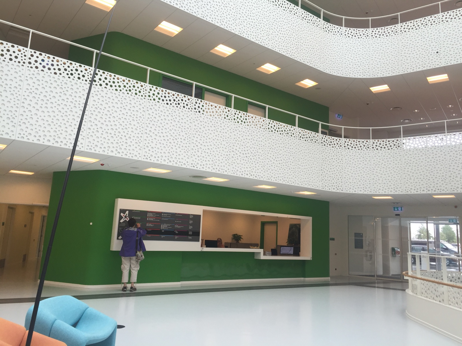 Interior of Handicaporganisationernes Hus with green perforated balcony panels around a central hall