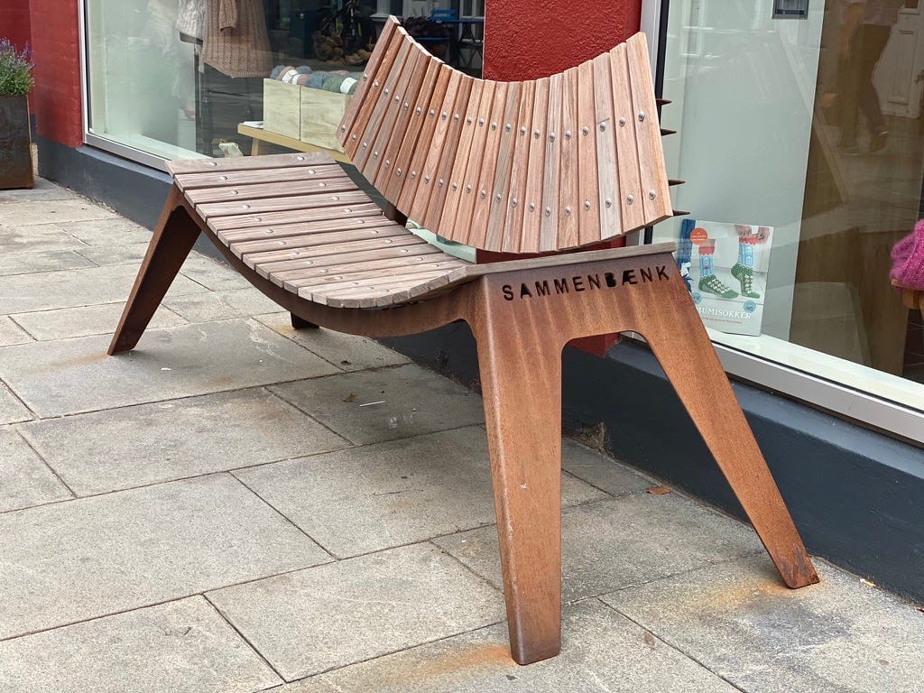 A Bench that leans inward, gently forcing people together.