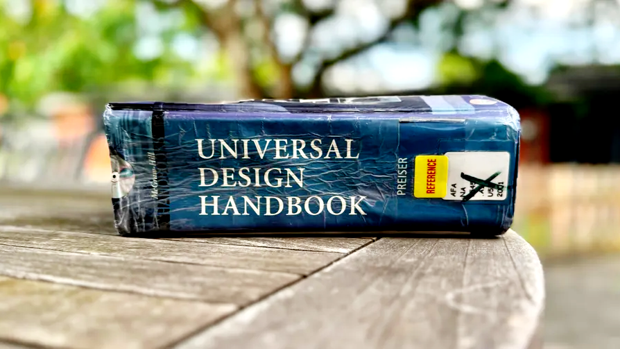 A close-up photograph of my wrinkled, worn copy of the “Universal Design Handbook” by Preiser and Ostroff from 2001 [1].