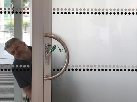 I am outside, looking through a glass door. A sign says "Only exit for", plus a wheelchair and a baby sign. I wonder where the baby's parents go.