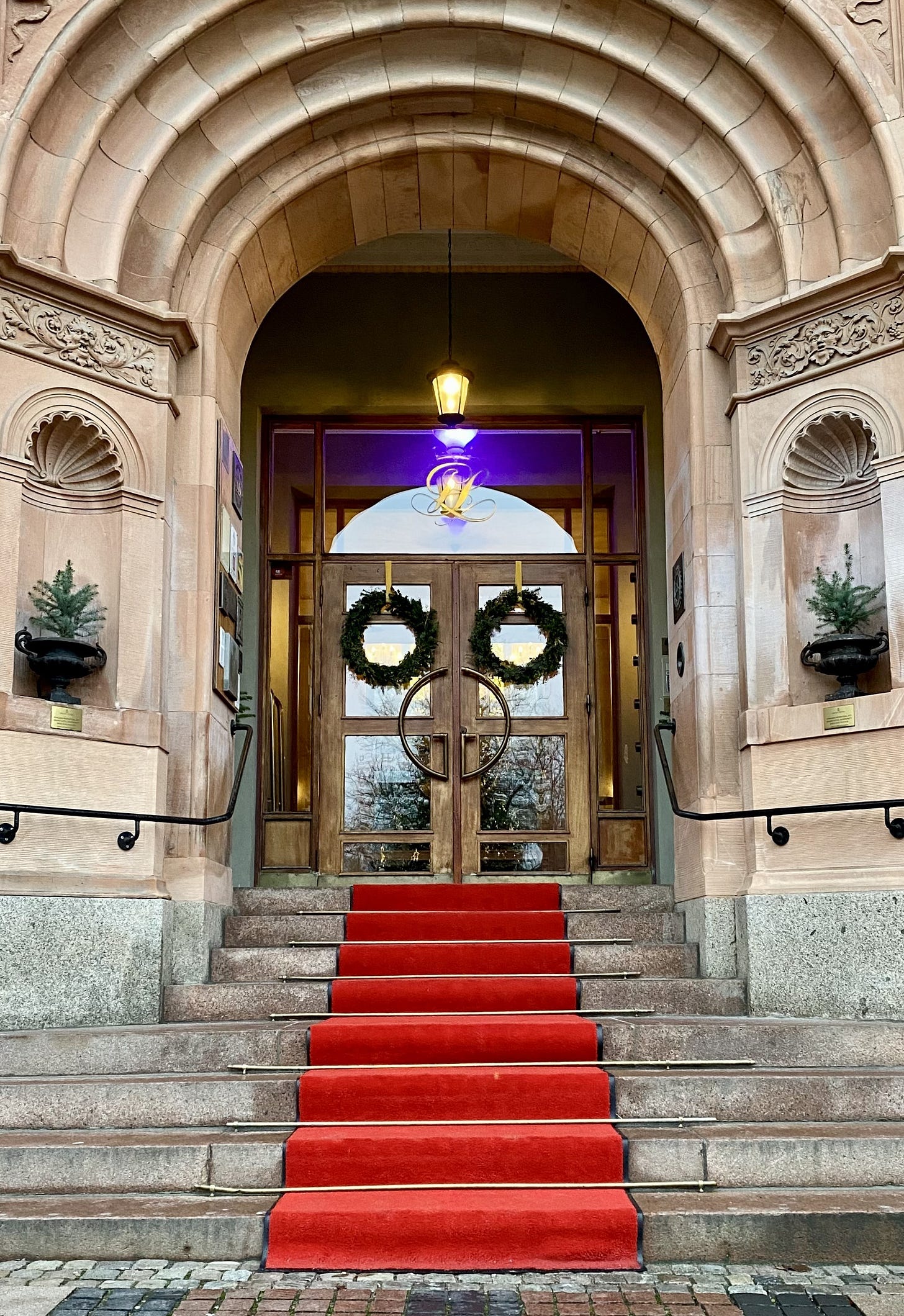 Hotel entrance with 8 steps to get in, and a red carpet draped over the staircase.