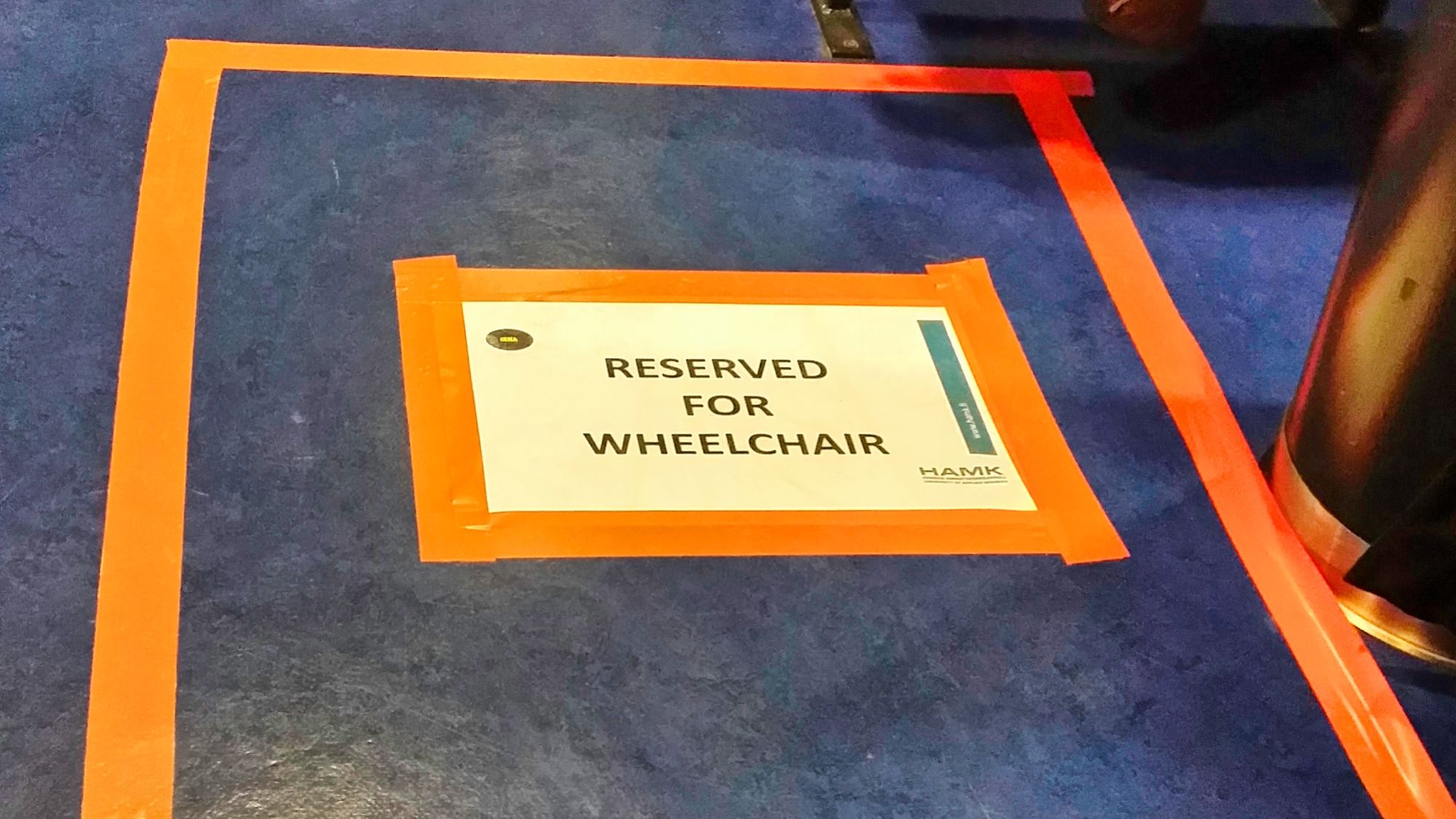 A sign reserving a parking space for wheelchair users.
