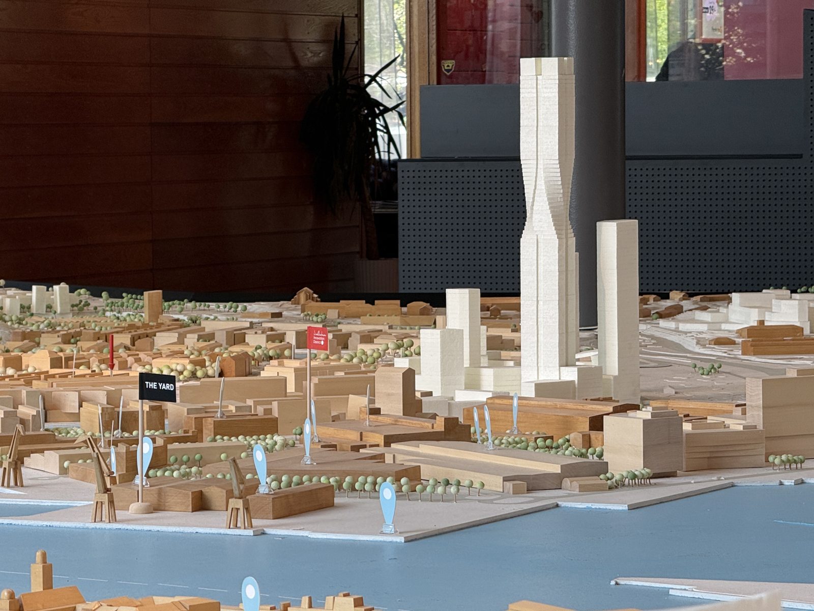 Älvstadsmodellen i Göteborg i skala 1:400. Den befintliga staden i trä, de planerade husen i vitt, älven i ljusblått med hamnkranar, och små flaggor som markerar The Yard och Lindholmen Innovation District. Karlatornet reser sig i mitten.